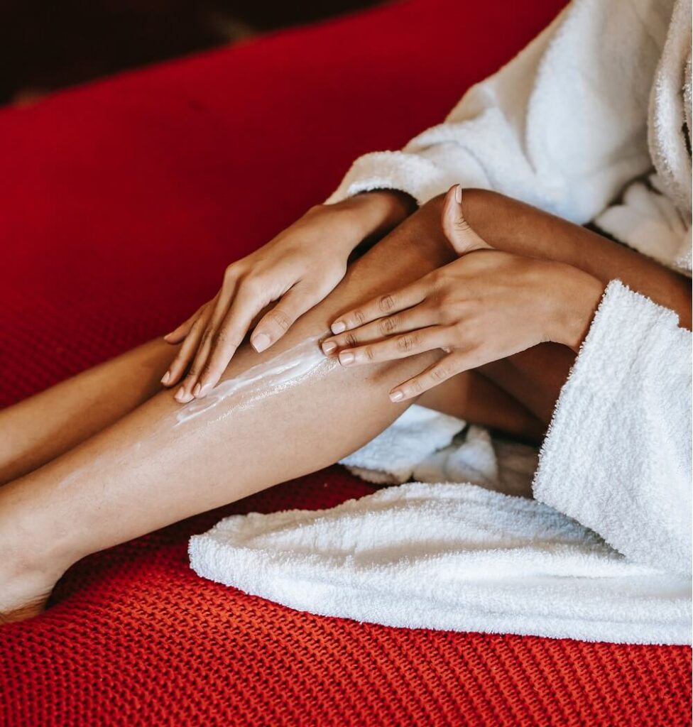 Woman moisturizing her legs