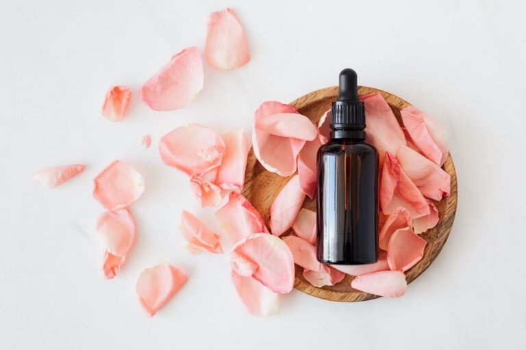 A cosmetic bottle resting on pink rose petals
