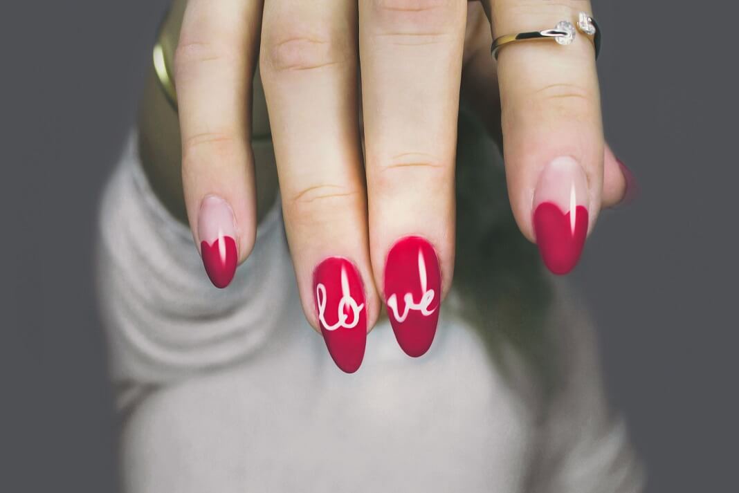Acrylic nails with "love" written on them