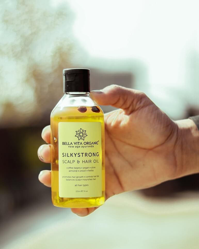 Photo of someone holding a bottle of hair oil