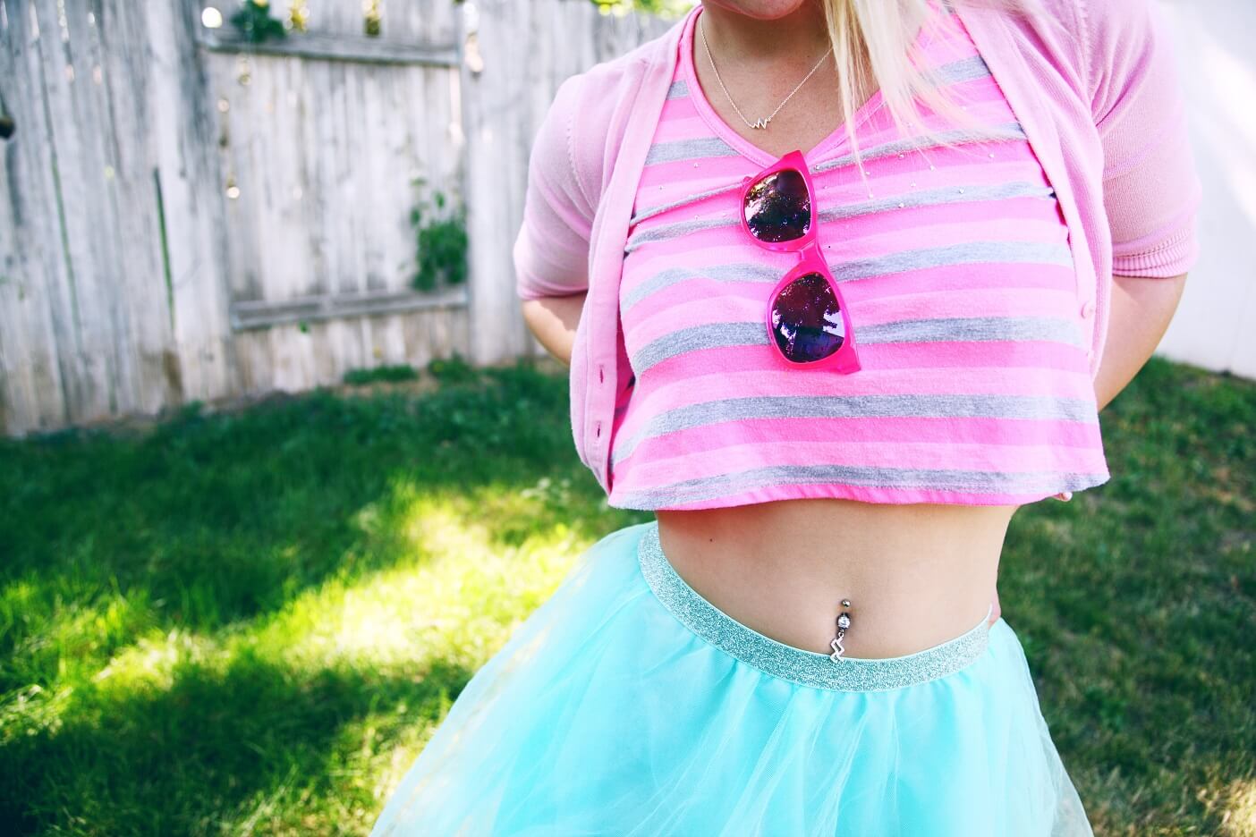 Woman in pink striped shirt and blue skirt with pierced belly button