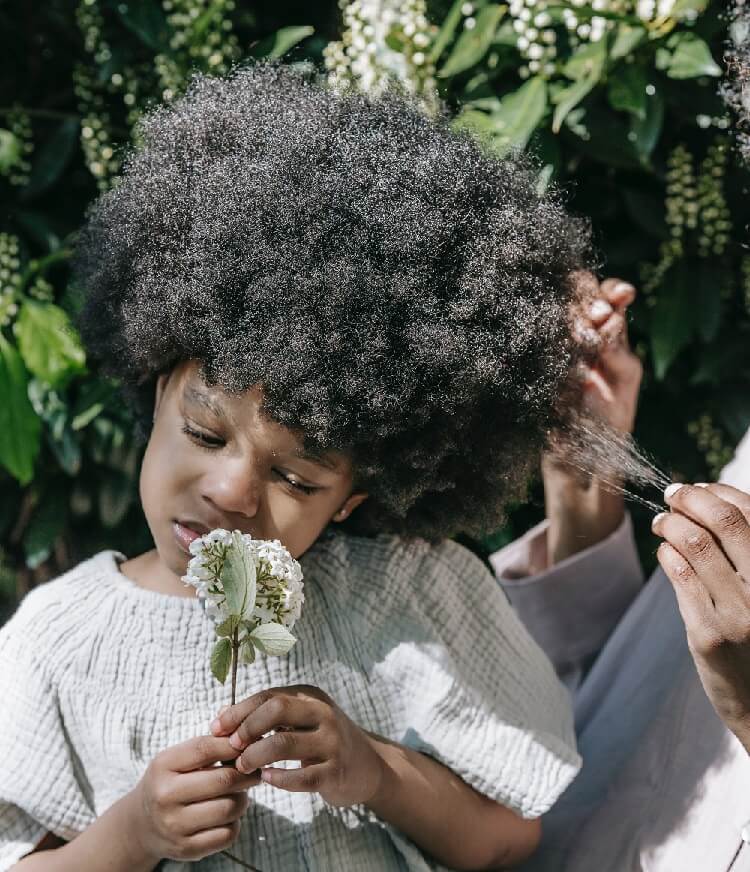 a person holding the hair of a girl holding white flowers