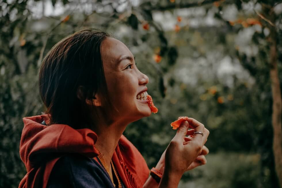 Woman biting orange fruit