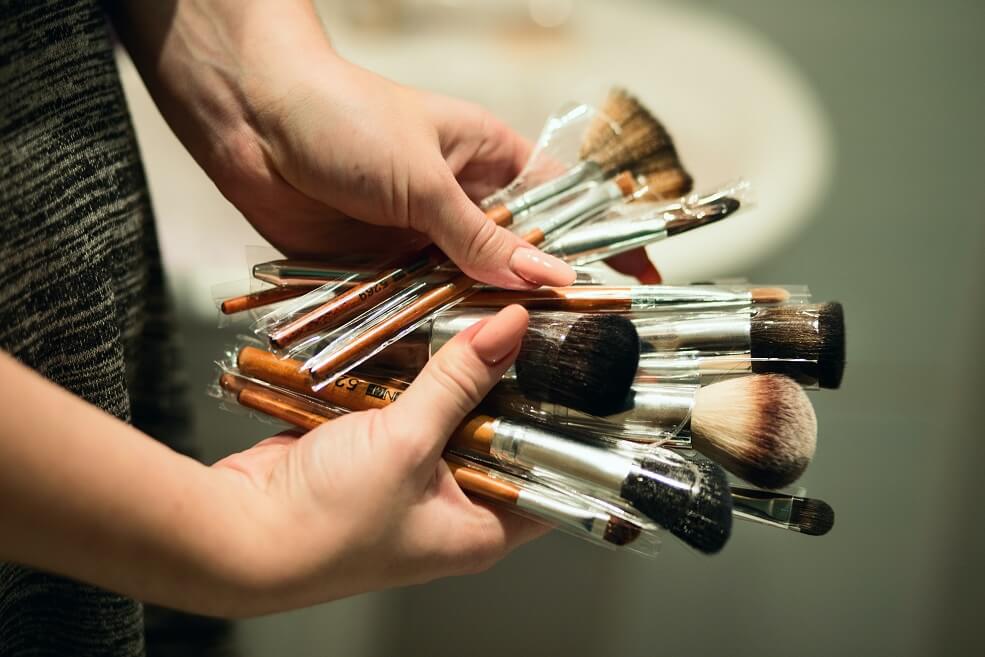 Person holding makeup brushes fanned out