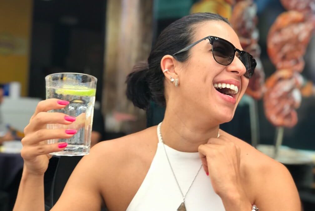 Woman laughing while holding a glass of water