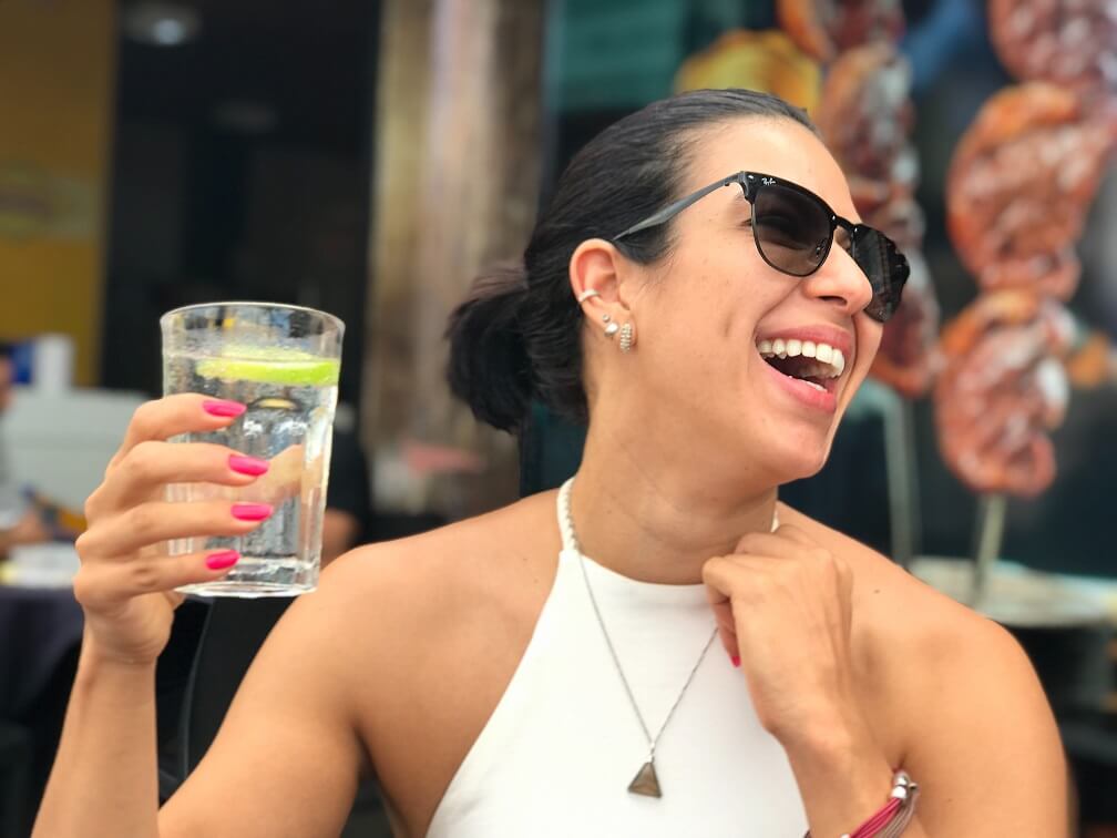 Woman laughing while holding a glass of water