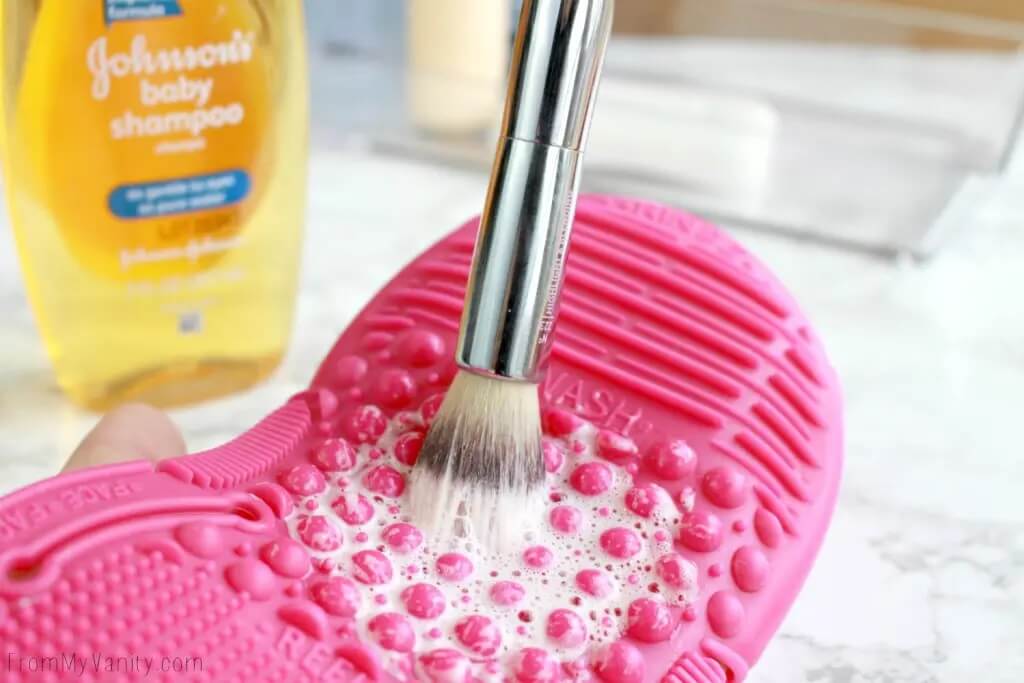 Cleaning a makeup brush on a cleansing mat