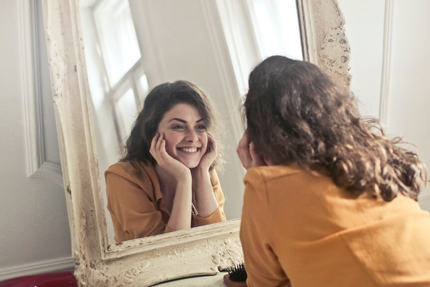 Femme souriant à elle-même dans un miroir
