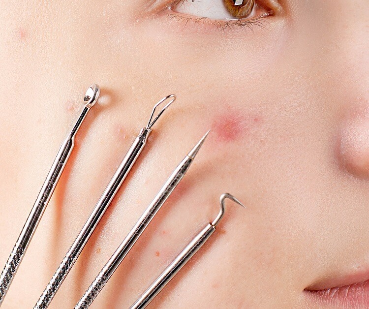 womans face with four skin extractor tools